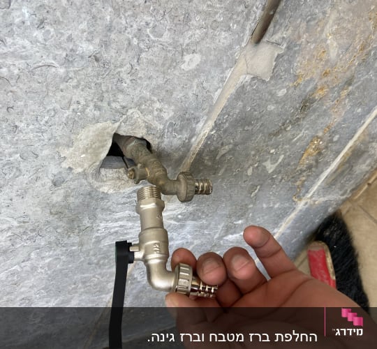 יד מחזיקה ברז מים מחובר לקיר